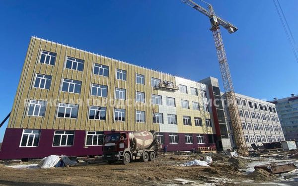 Строители облицовывают фасад школы по лице Флотской в Брянске